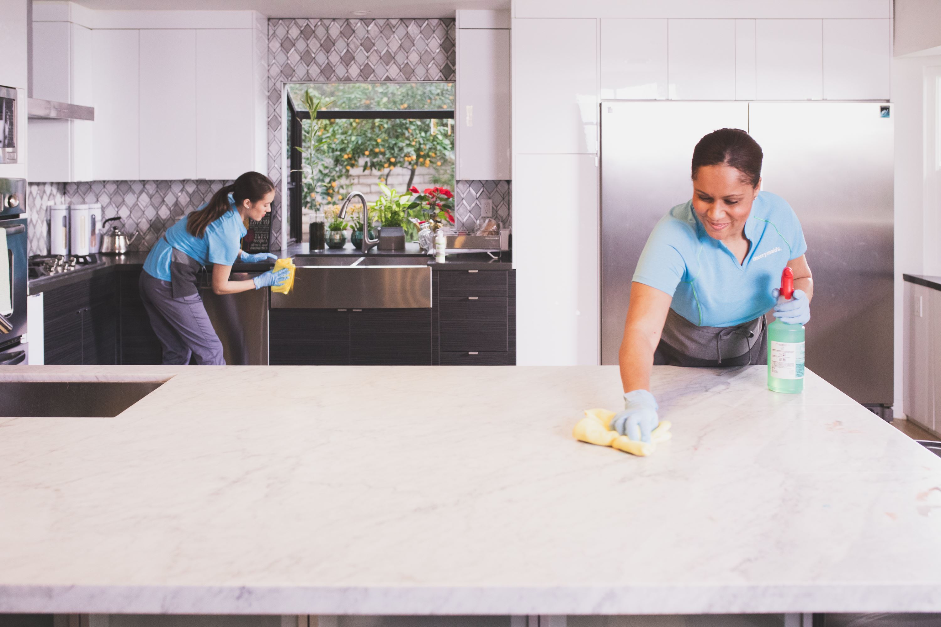  Merry Maids team members sanitizing a kitchen during house cleaning services