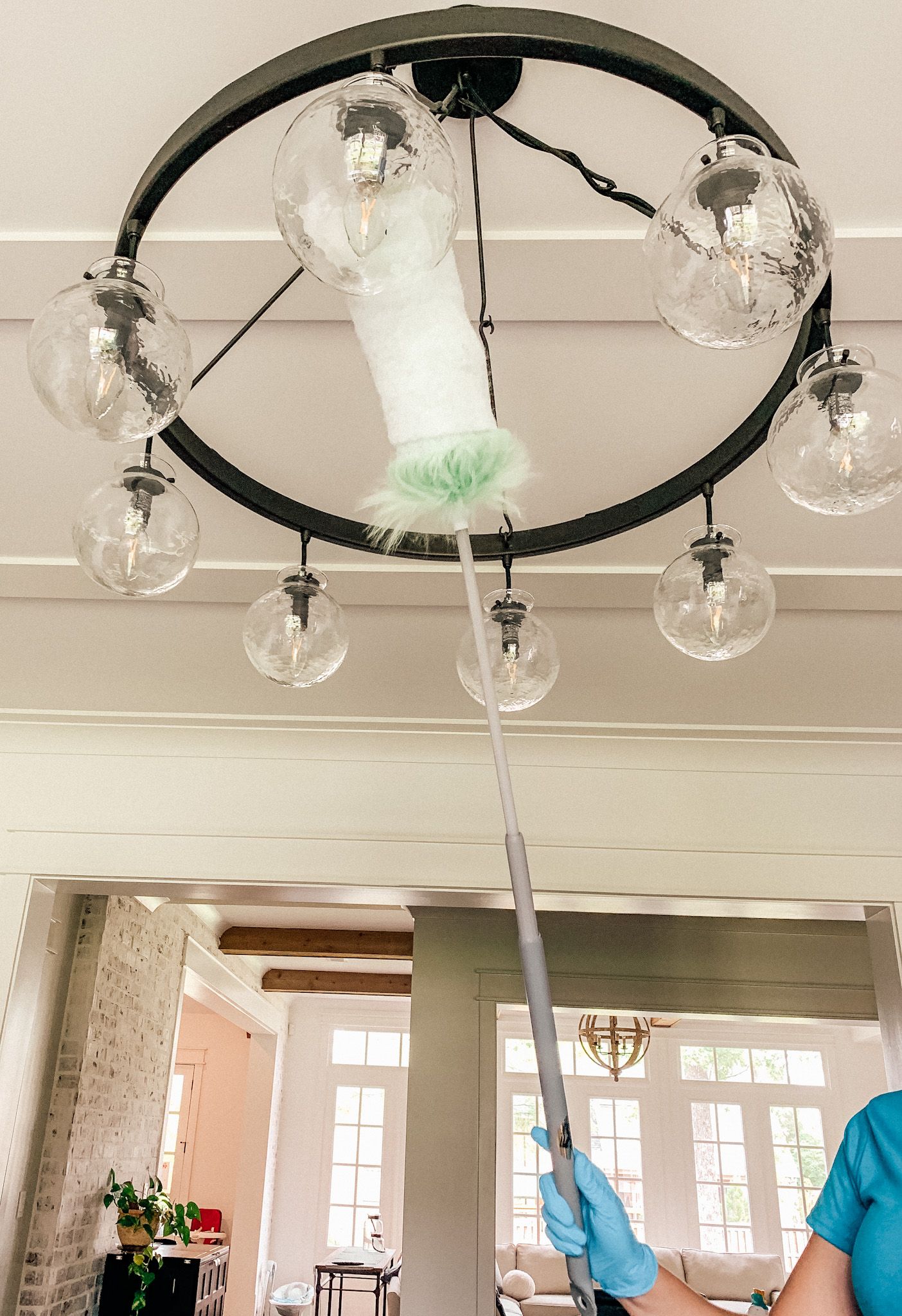 A light fixture being dusted by a Merry Maids professional during move in cleaning in Knoxville, Tennessee