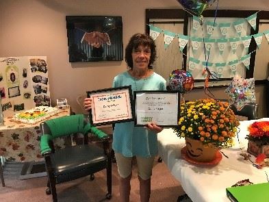Cathy Folger, Merry Maids employee holding awards