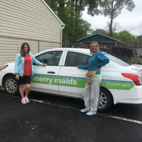 Two Women in Front of the Merry Maids Car