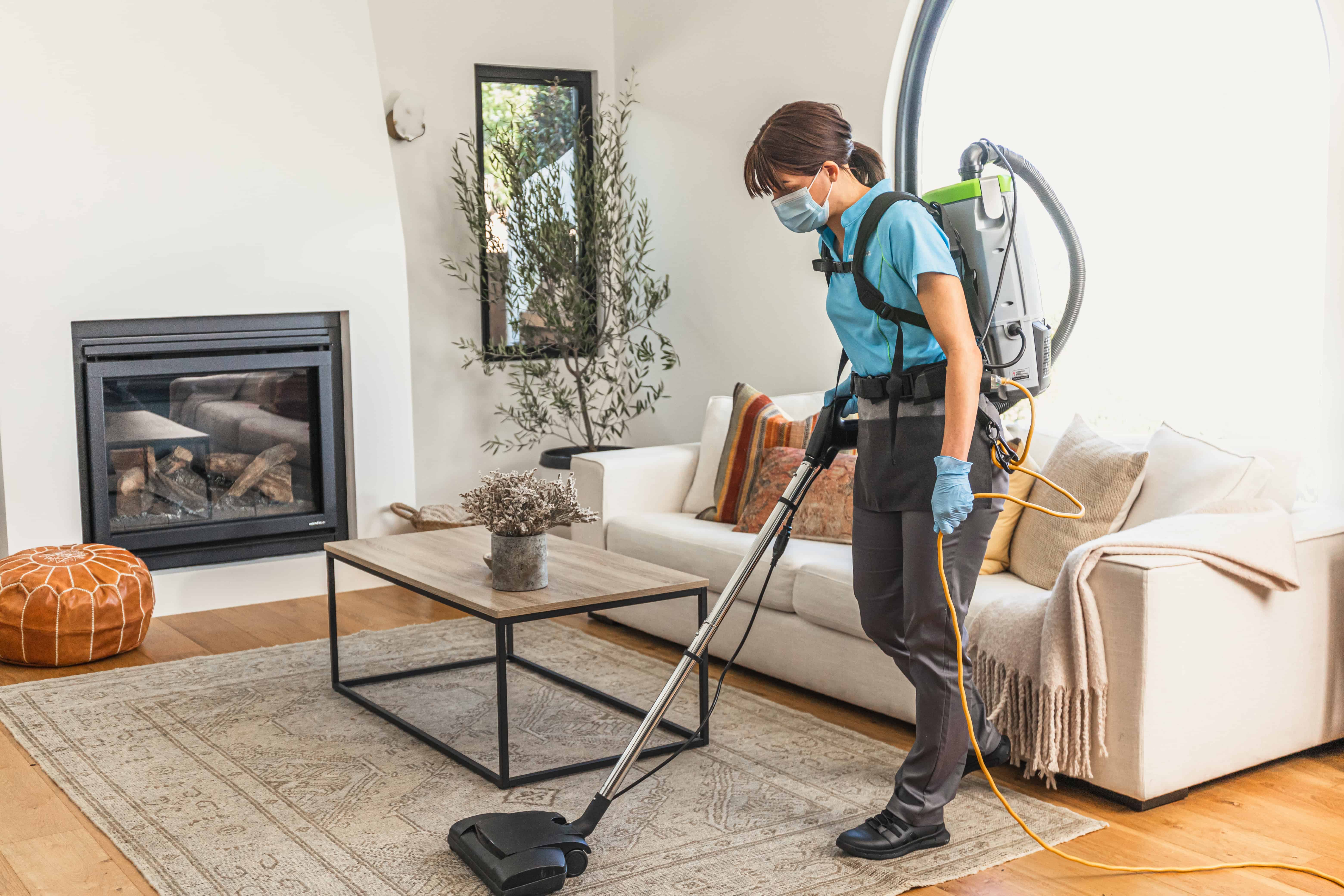 Professional vacuuming living space while house cleaning
