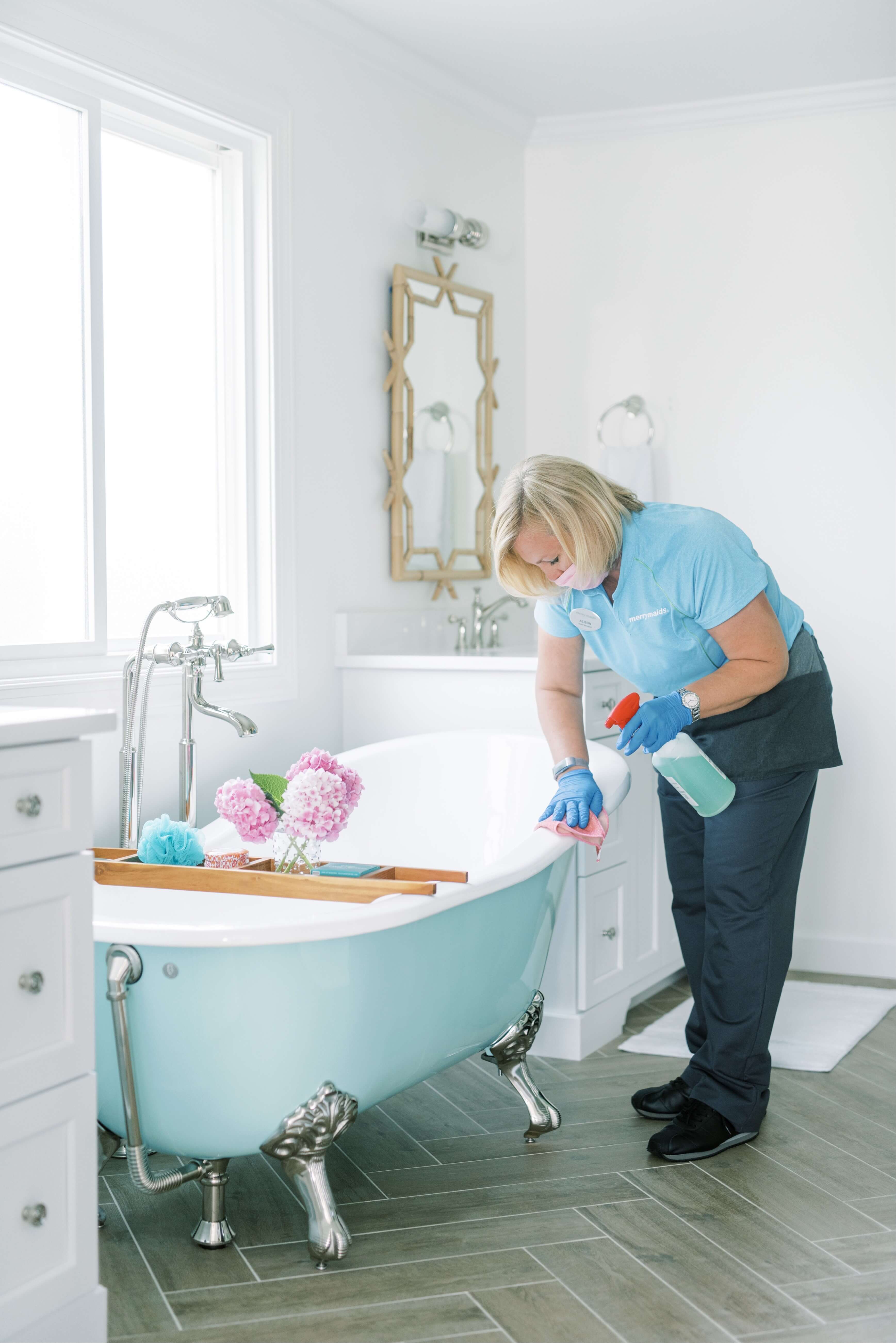Merry Maids team member cleaning bathtub